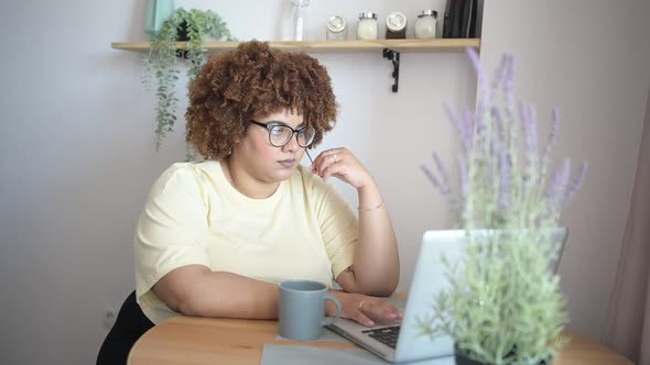 Attractive Happy Stylish Plus Size African Black Woman Student Afro Hair in Glasses Studying Online