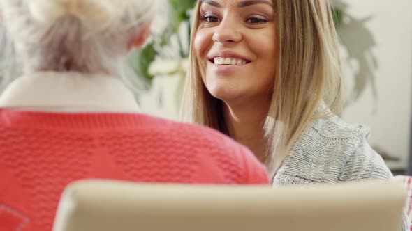 Joyous Woman Drinking Tea and Chatting with Grandmother