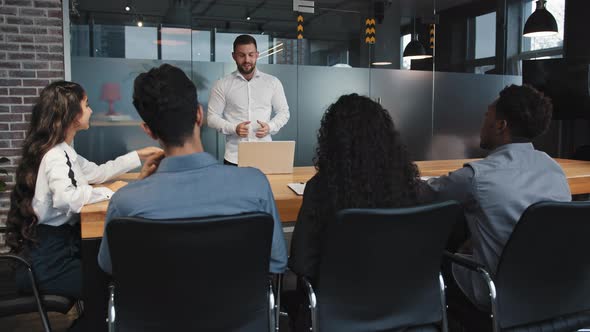 Young Team Leader Make Presentation in Conference Room to Multiracial Employees Confident Male alt