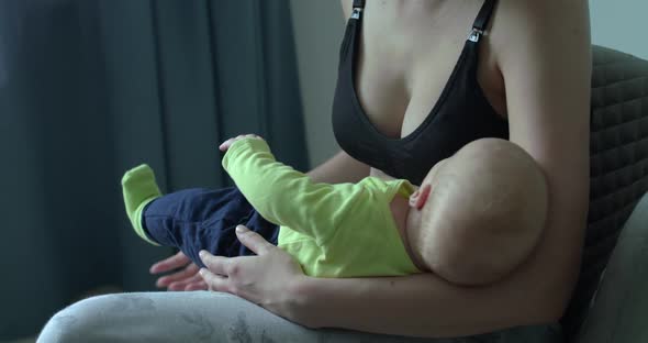 Unrecognizable Mom Holds Her Little Baby Boy on Hands in Room alt