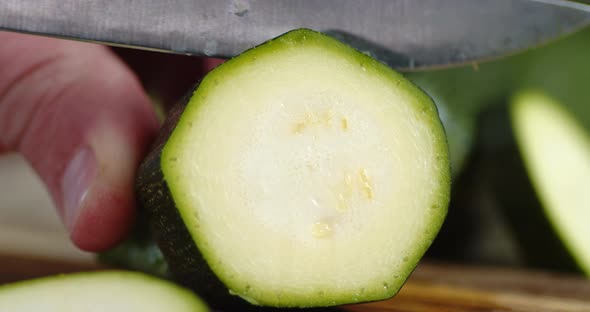 Hand Men Cuts a Piece of Ripe Zucchini alt
