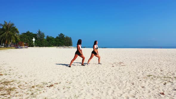 Female models look beautiful on tranquil bay beach holiday by blue green sea with white sand backgro alt