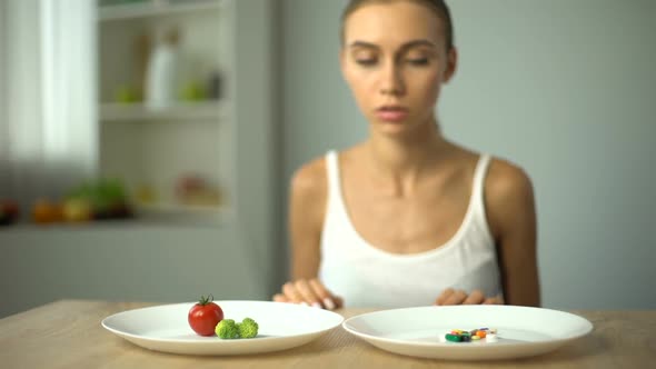 Anorexic Girl Choosing Weight Loss Drugs Instead of Vegetables, Unhealthy Diet alt