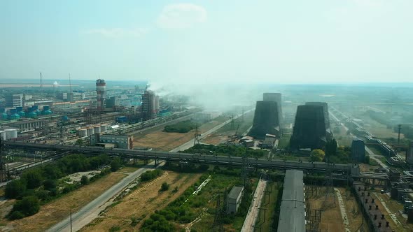 Quadcopter Flies Over the Territory of the Plant, Huge Pipes and Workshops. Smoke Comes Out
