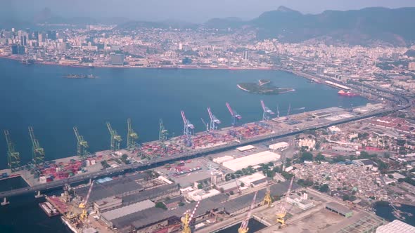 Flying over the port area of Rio de Janeiro with its machinery and stock areas and in the background alt