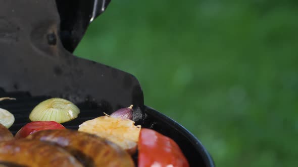 Grilled Sausages are Fried with Zucchini Peppers and Tomatoes on a Black Grill Grill