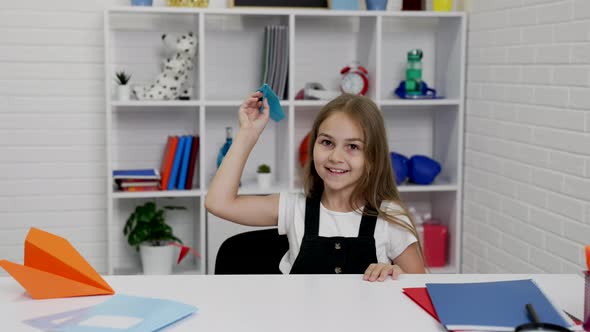 Happy Kid Having Fun Playing with Paper Plane at School Lesson in Classroom School Time alt