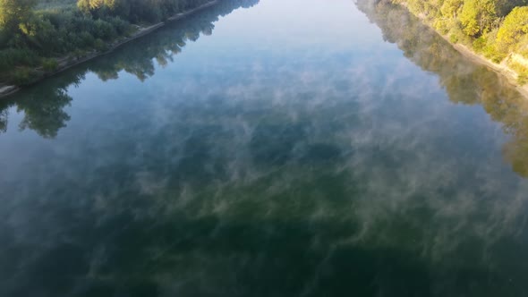 Aerial drone view of nature of Moldova at sunset. River and lush fog above it greenery alt