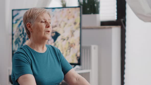 Close Up of Pensioner Doing Meditation While Sitting on Toning Ball alt