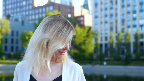 portrait of a beautiful blonde woman against the backdrop of a big city