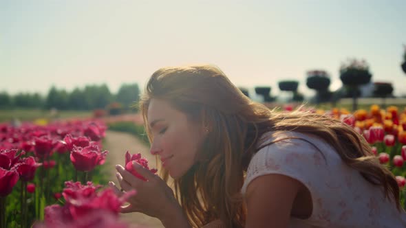 Emotional Girl Smelling Flowers in Sunset Light alt