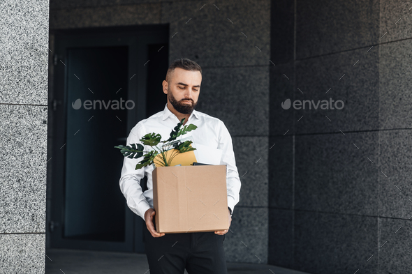 Jobless male worker moving out office with box full of personal belongings, lost job and left