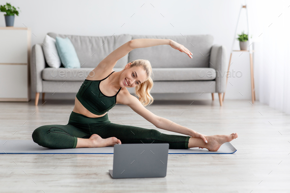 Active woman doing stretching exercise in living room at home - Stock Photo - Images