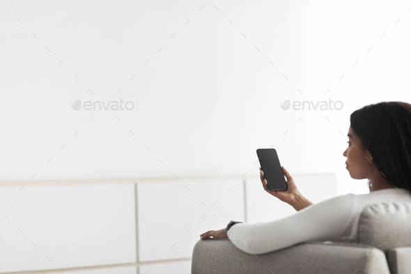 Concept of smart home and mobile application for managing smart devices at home. Black woman