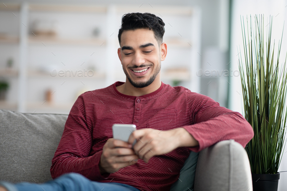 Happy arab man enjoying new mobile application - Stock Photo - Images