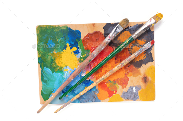 Painter's palette with oil paint and brushes on white back…