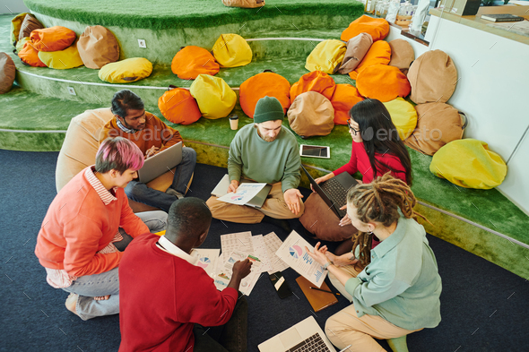 Group of young intercultural financial managers in casualwear discussing papers - Stock Photo - Images
