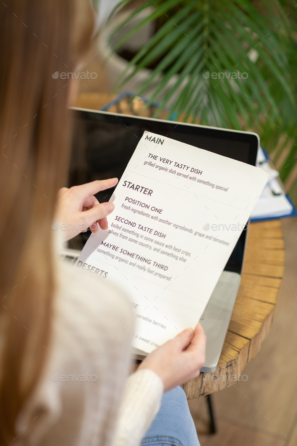 Long-haired woman working with the menu card - Stock Photo - Images