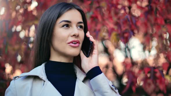 Happy Woman Talking Use Smartphone Near Autumn Tree Foliage alt