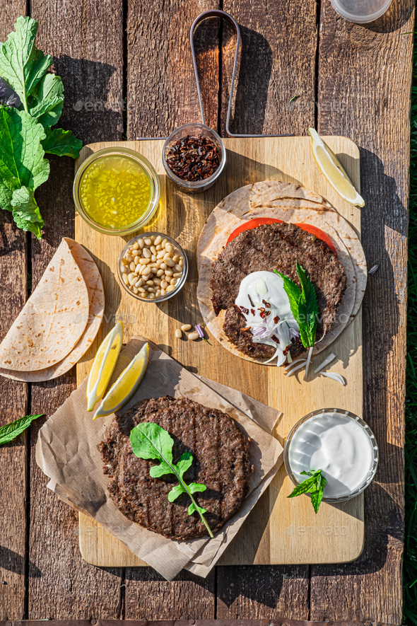 Spicy lamb kebab patties served with mint dip, crunchy salad, pitta bread and raw red onions