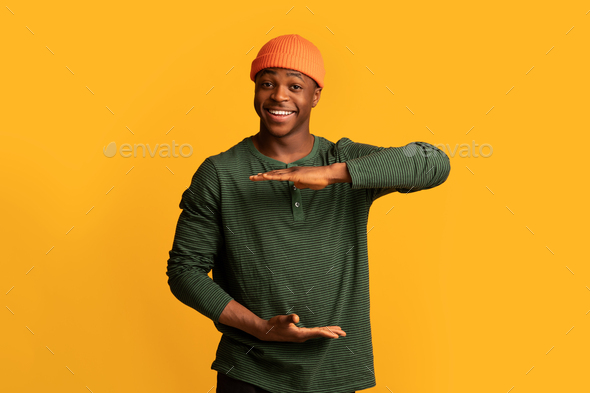 Cheerful African American Guy Measuring Invisible Object With His Hands - Stock Photo - Images