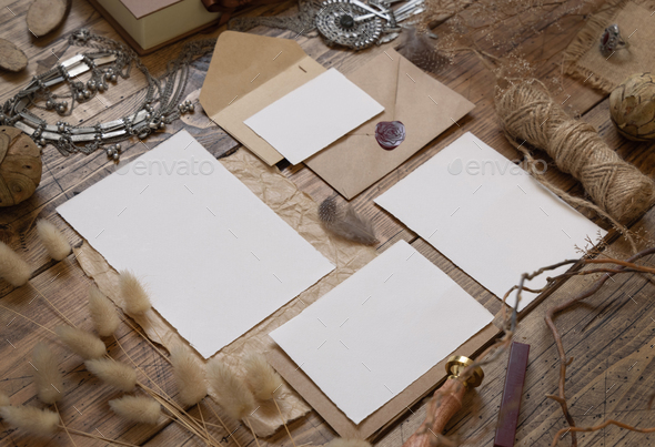 Wedding blank cards laying on a wooden table with bohemian decoration around