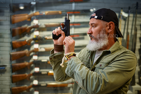 Bearded man twitches the pistol bolt in gun store