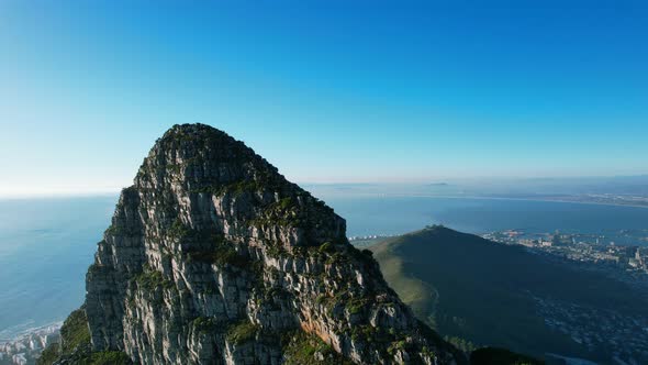 zoom out aerial of Lions Head Mountain peak in Cape Town South Africa at sunset alt
