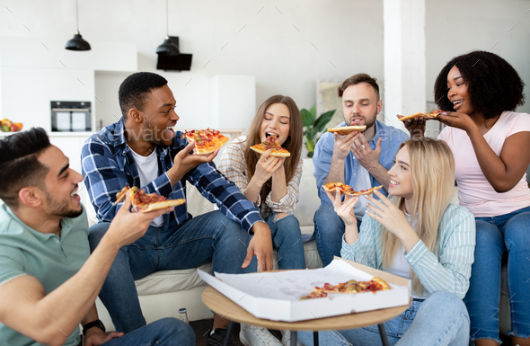 Happy african american friends eating pizza at home Stock Photo by  Prostock-studio