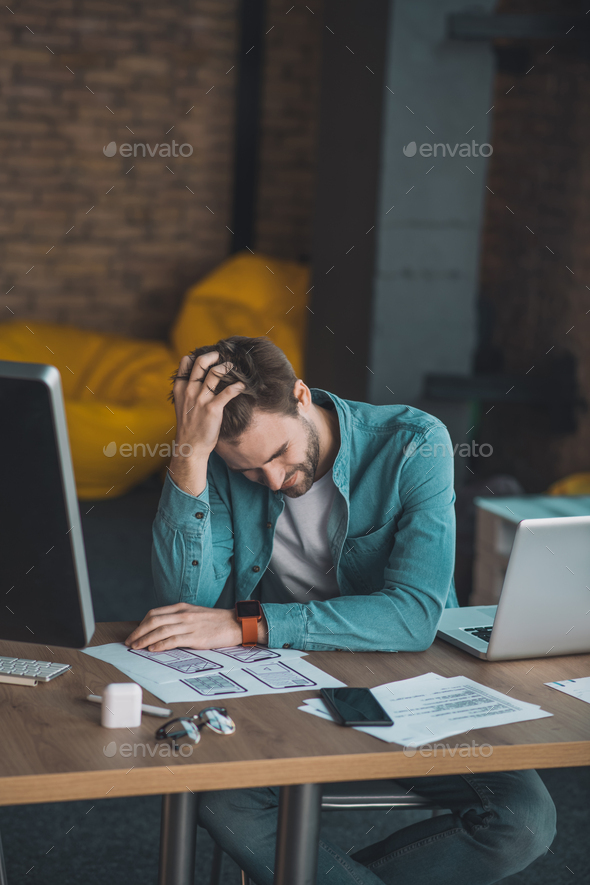 Depressed young man being tired from his work
