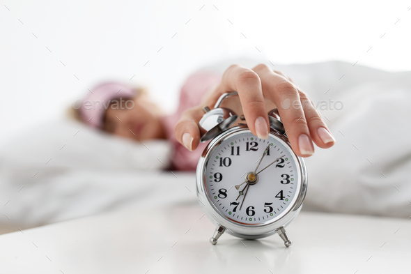 Lady lying on bed and trying wake up, get up early for work