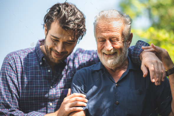 caucasian senior father and adult son hugging together at home, family ...