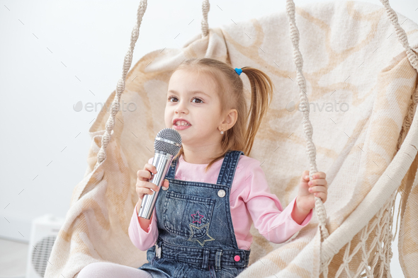 A small cheerful child learns to sing songs. The concept of chil