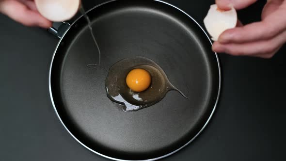 Broken egg falls into the frying pan. Close up. HD