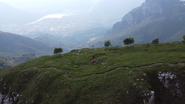 Hikers sitting on meadow during break, European Alps, Lecco, Italy