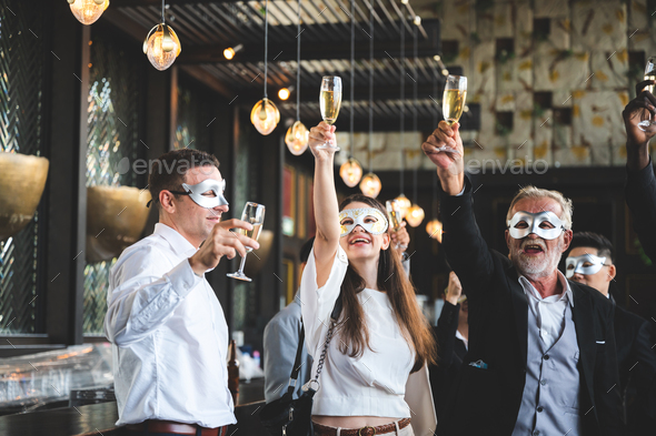 business team party, businessman and businesswomen wearing fancy mask