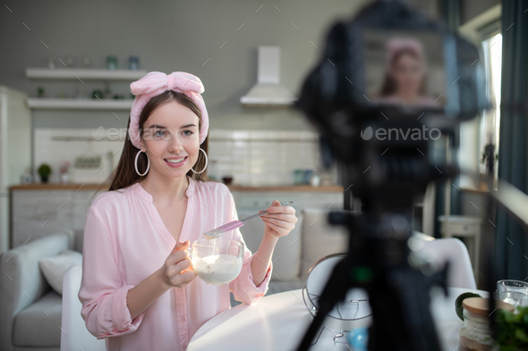 Young pretty girl in a pink headband giving tips on skin care