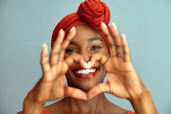 Black mature woman making heart shape and smile - Stock Photo - Images