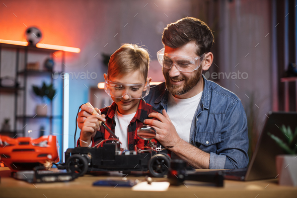 Father teaching son for soldering remote controlled toy car