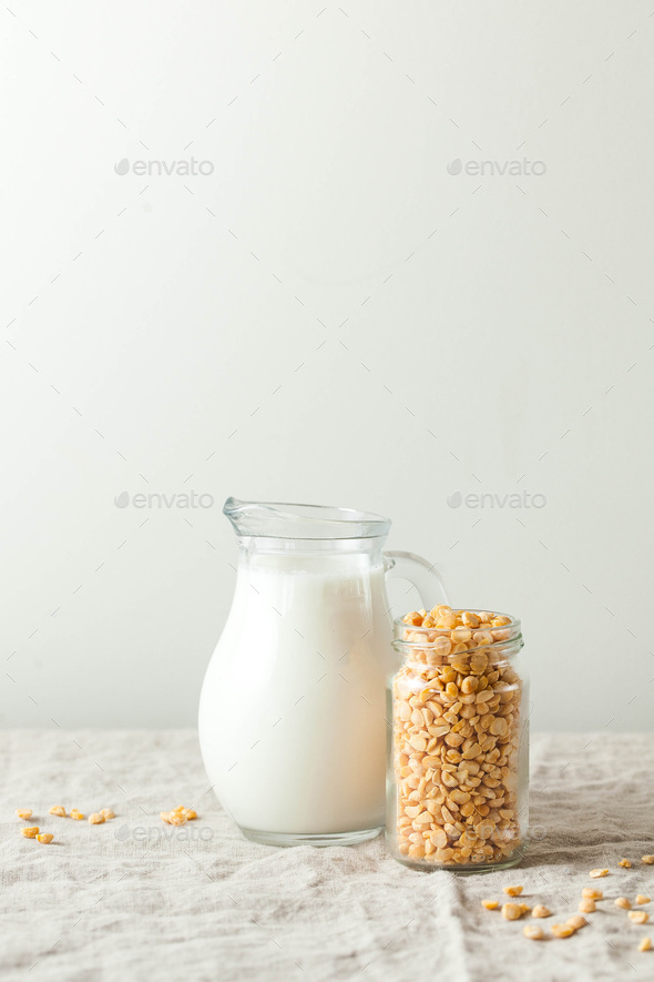 Vegetable pea milk in a milk jug and peas in a jar. Gluten-free, lactose-free product.