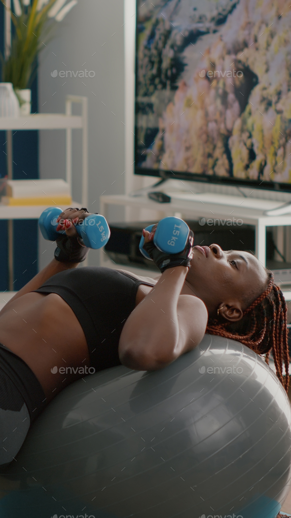 Athletic black woman doing morning fitness workout in living room Stock  Photo by DC_Studio