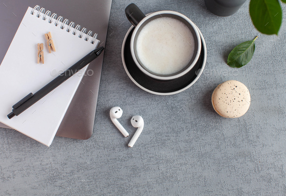 White Notepad, wireless headphones, coffee mug. The concept of online training, home office.
