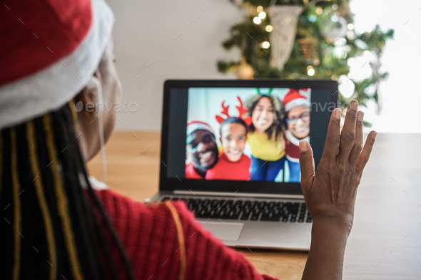 African senior woman doing video call with her family during Christmas time - Focus on right hand