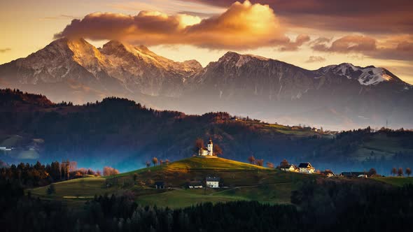 4K Timelapse Church of Saint Thomas at sunrise with Kamnisko Savinjske Alpe, Slovenia alt