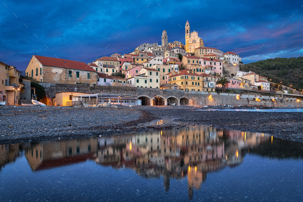 Cervo town reflecting in water at dusk, Liguria, Italy - Stock Photo - Images