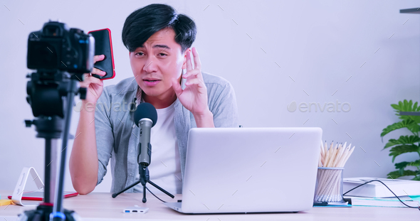 Young asian man selling digital gadgets on social media by streaming live from his home.
