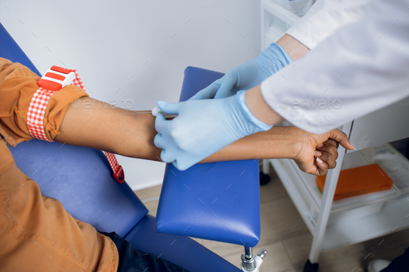 Close up cropped shot of hands of female doctor preparing patient for blood draw in modern clinic