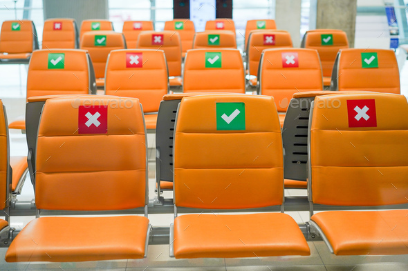 Row of empty bench chair seats with social distancing guidance during Coronavirus pandemic
