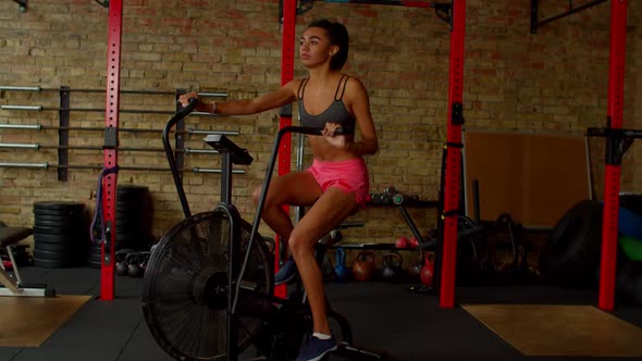 Lovely Active Sporty Fitness African American Female Riding Exercise Bike at Gym alt