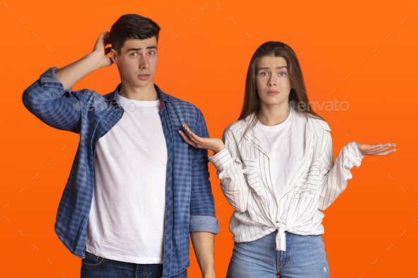 Puzzled young couple do not understand what happening or does something wrong